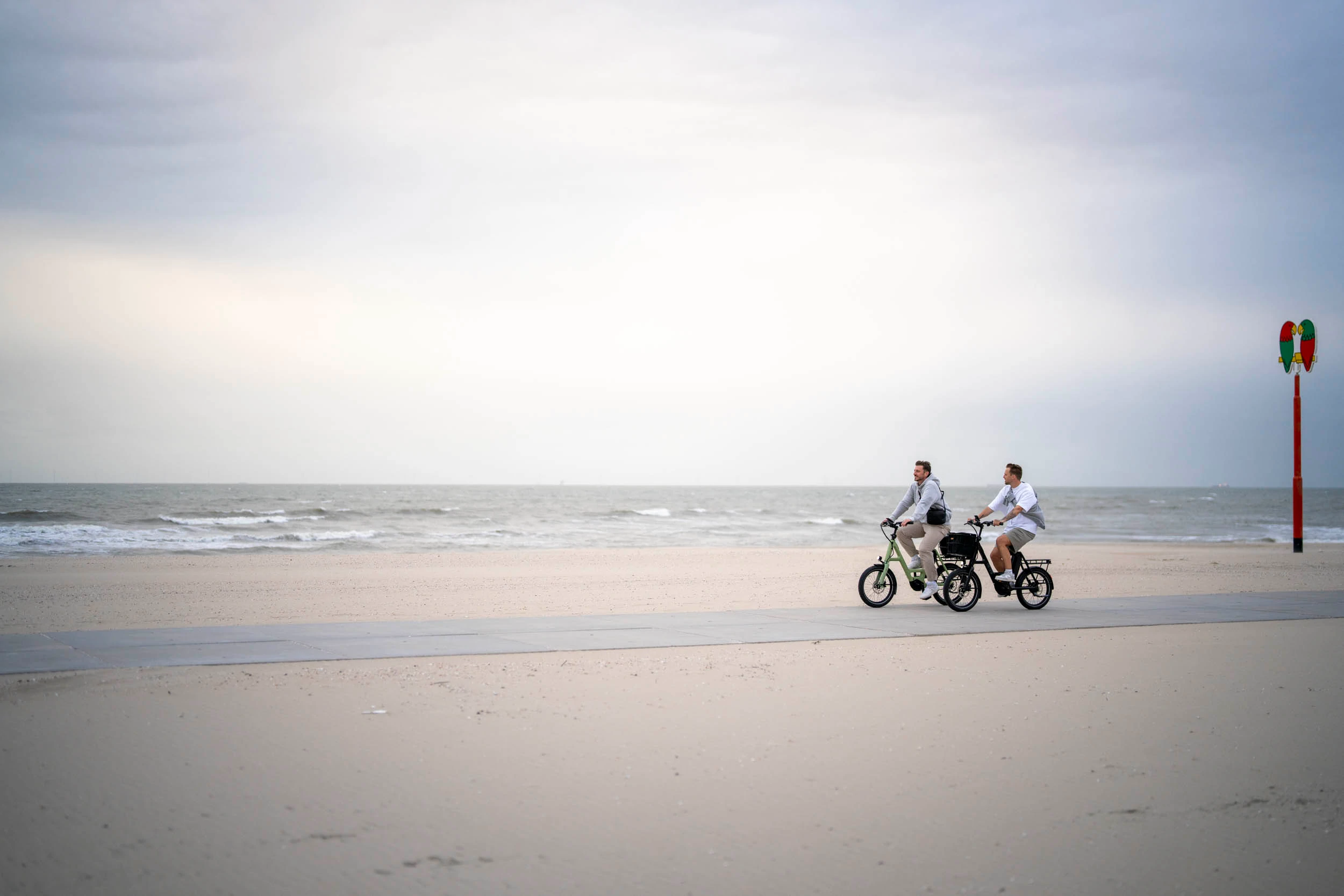 Zwei Männer auf i:SY E-Bikes am Strand